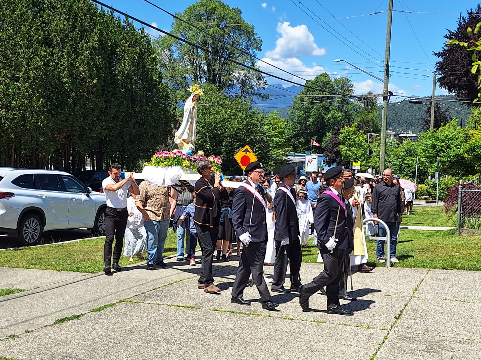 Parishioners and Knights walking together behind Mary's statue