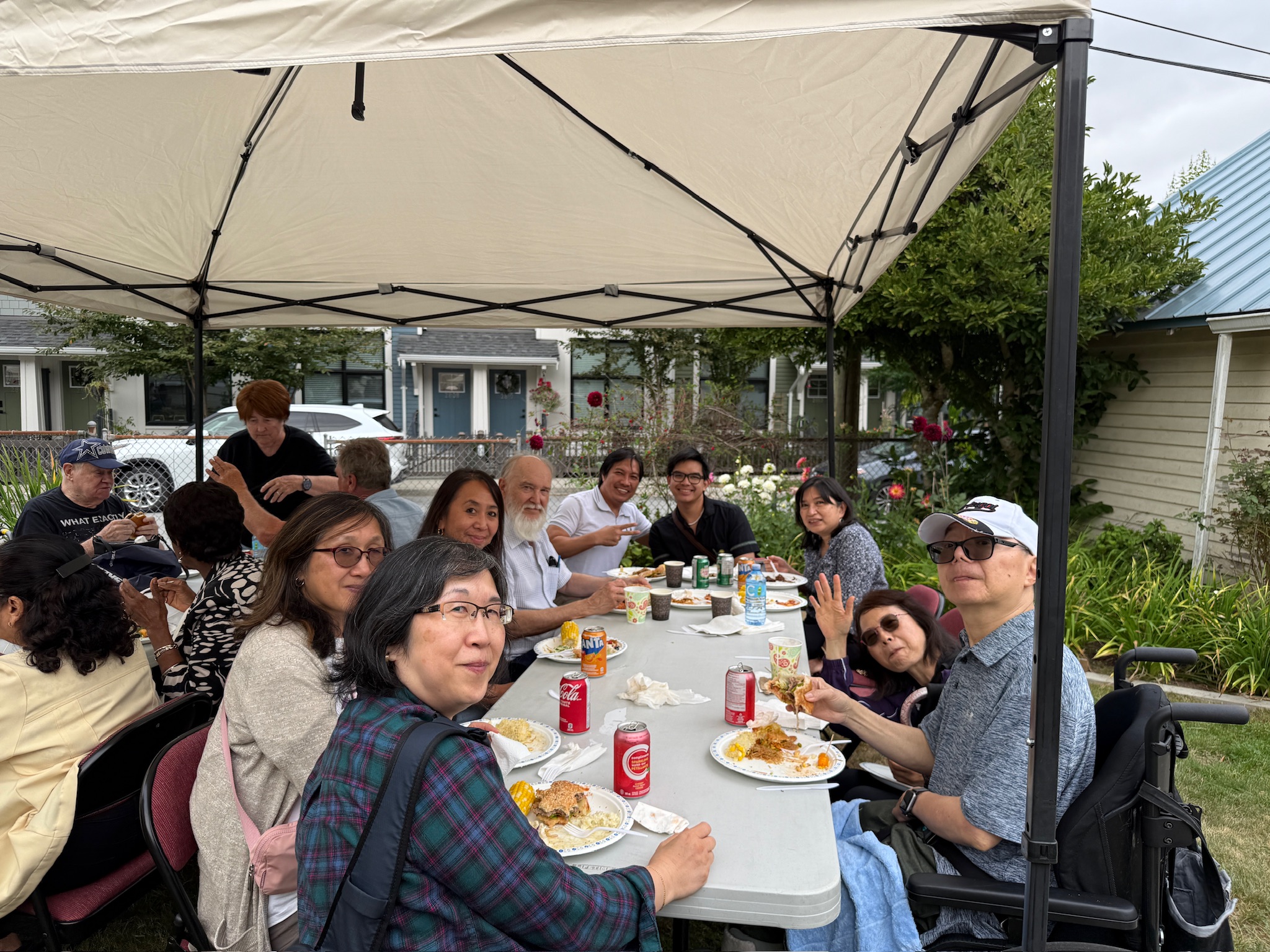 Families sharing lunch under canopy
