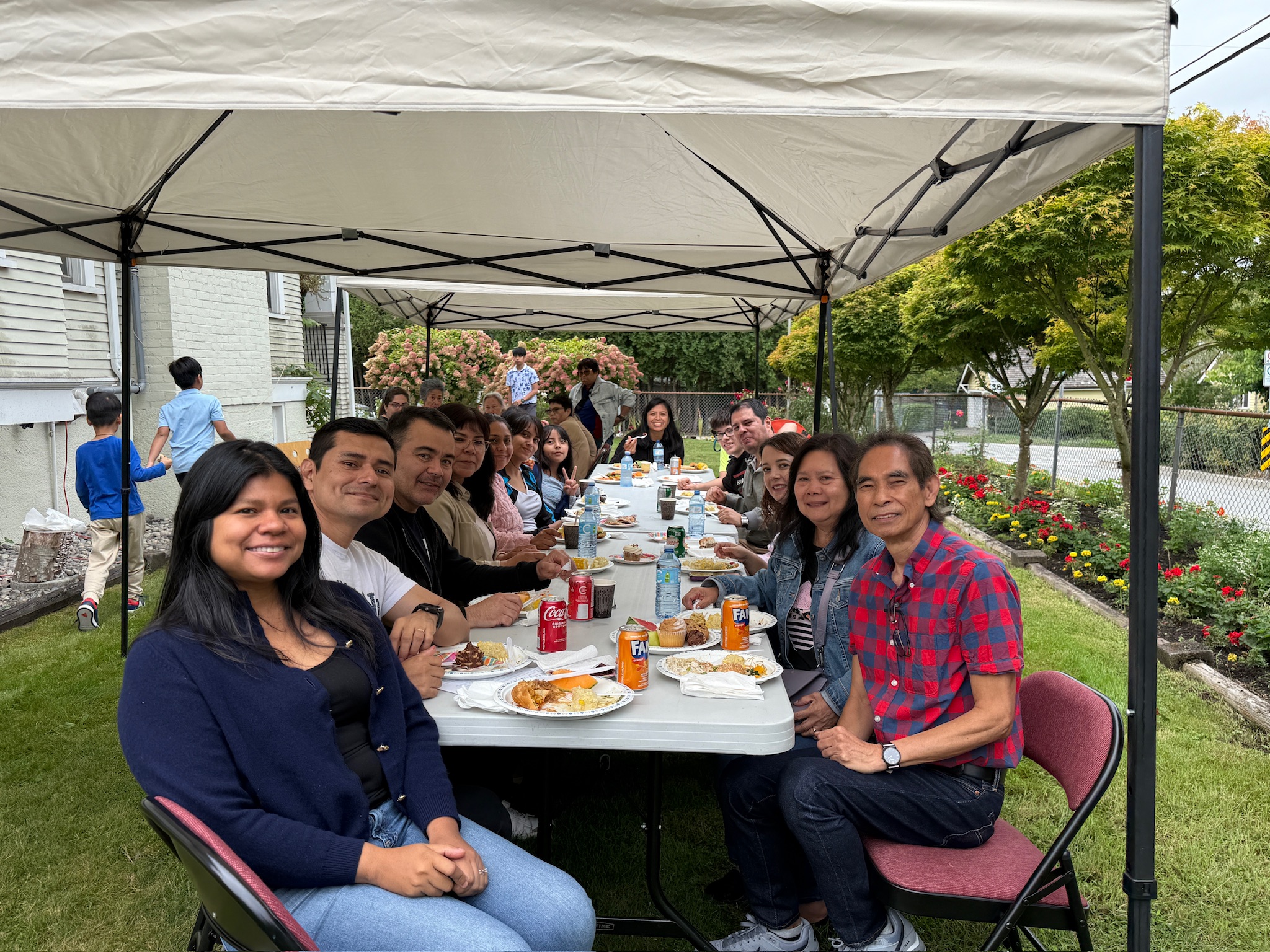 Long table of parishioners posing for a group photo during the picnic