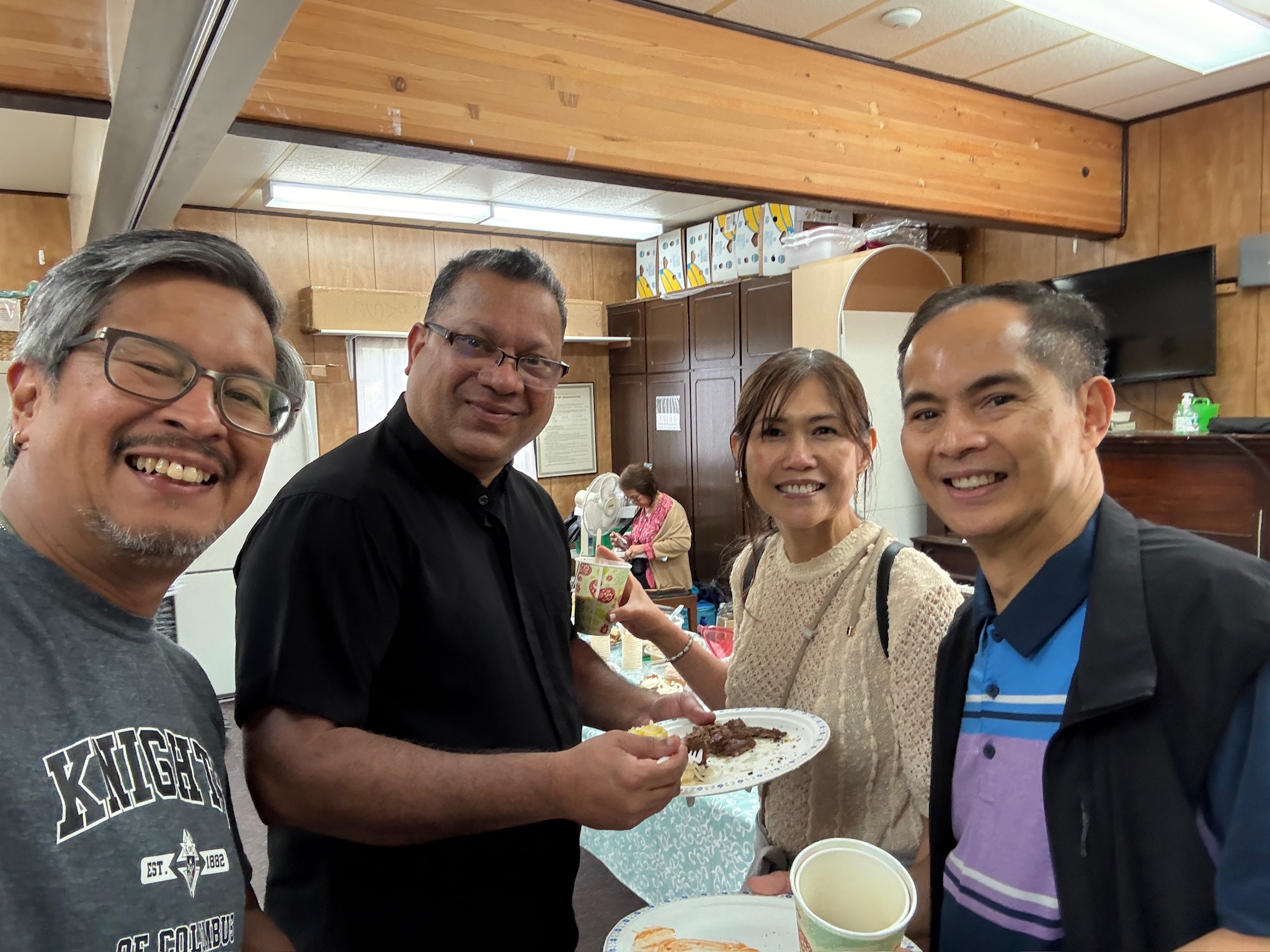 Friends taking a selfie with Father during the picnic
